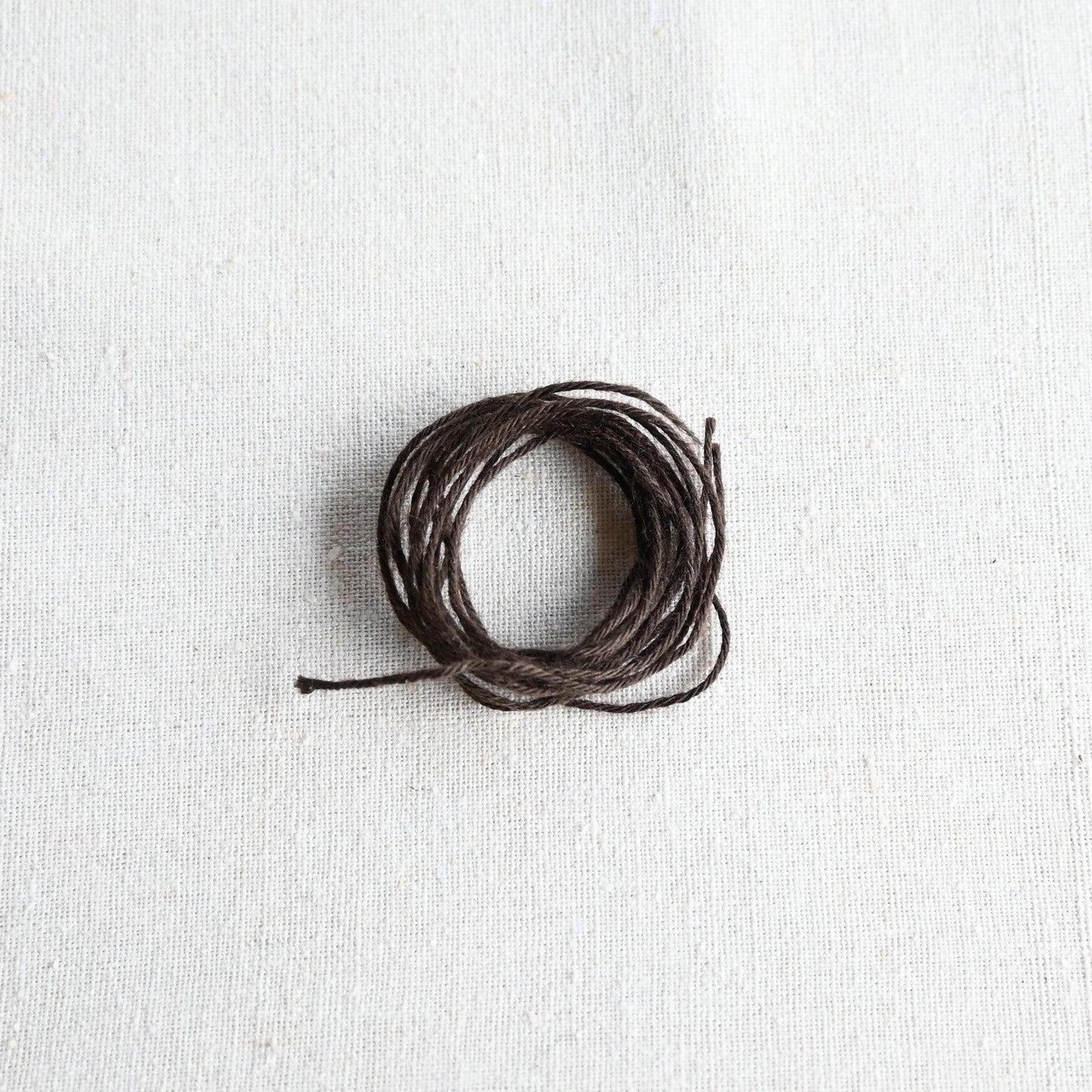 Authentic Japanese Hida sashiko threads in brown on calico cotton.