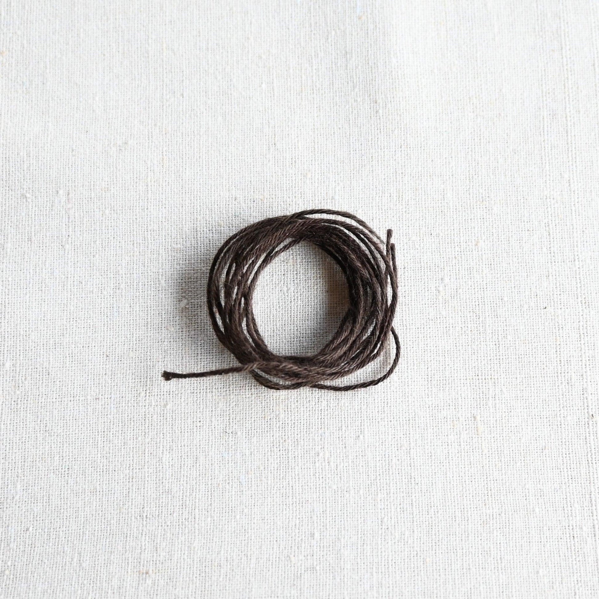 Authentic Japanese Hida sashiko threads in brown on calico cotton.