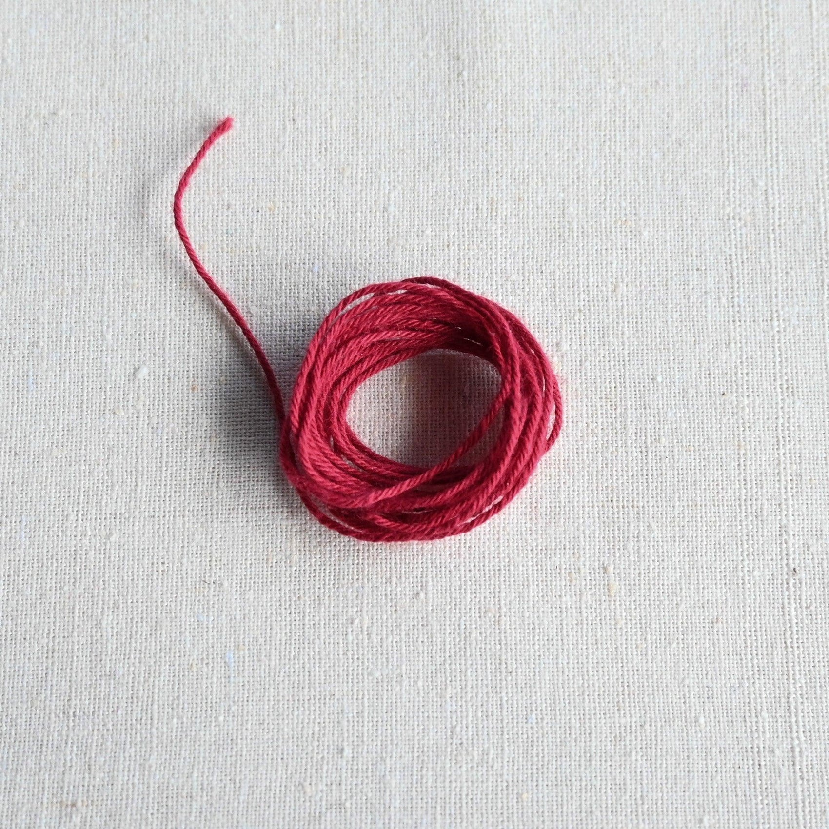 Authentic Japanese Hida sashiko threads in burgundy on calico cotton.