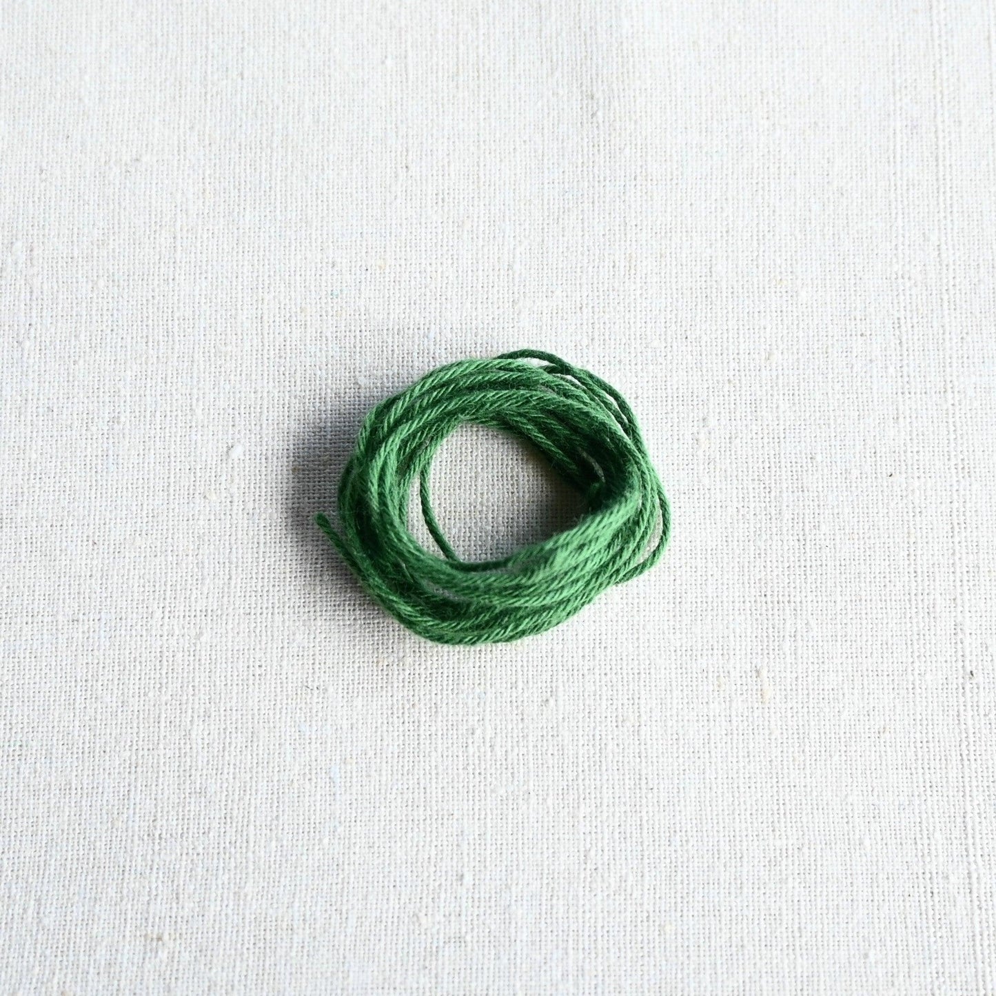 Authentic Japanese Hida sashiko threads in green on calico cotton.
