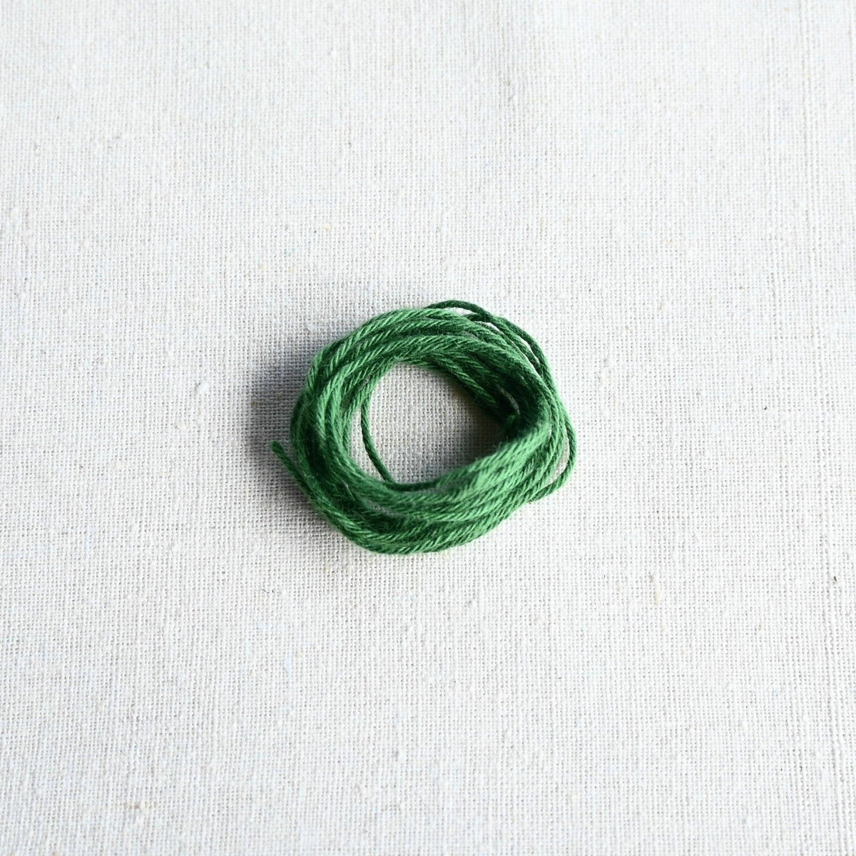 Authentic Japanese Hida sashiko threads in green on calico cotton.