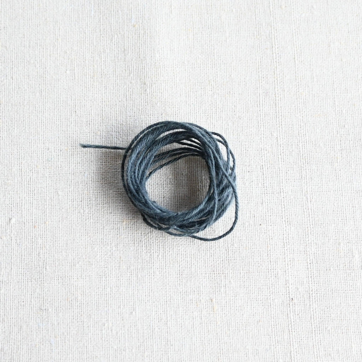 Authentic Japanese Hida sashiko threads in grey on calico cotton.