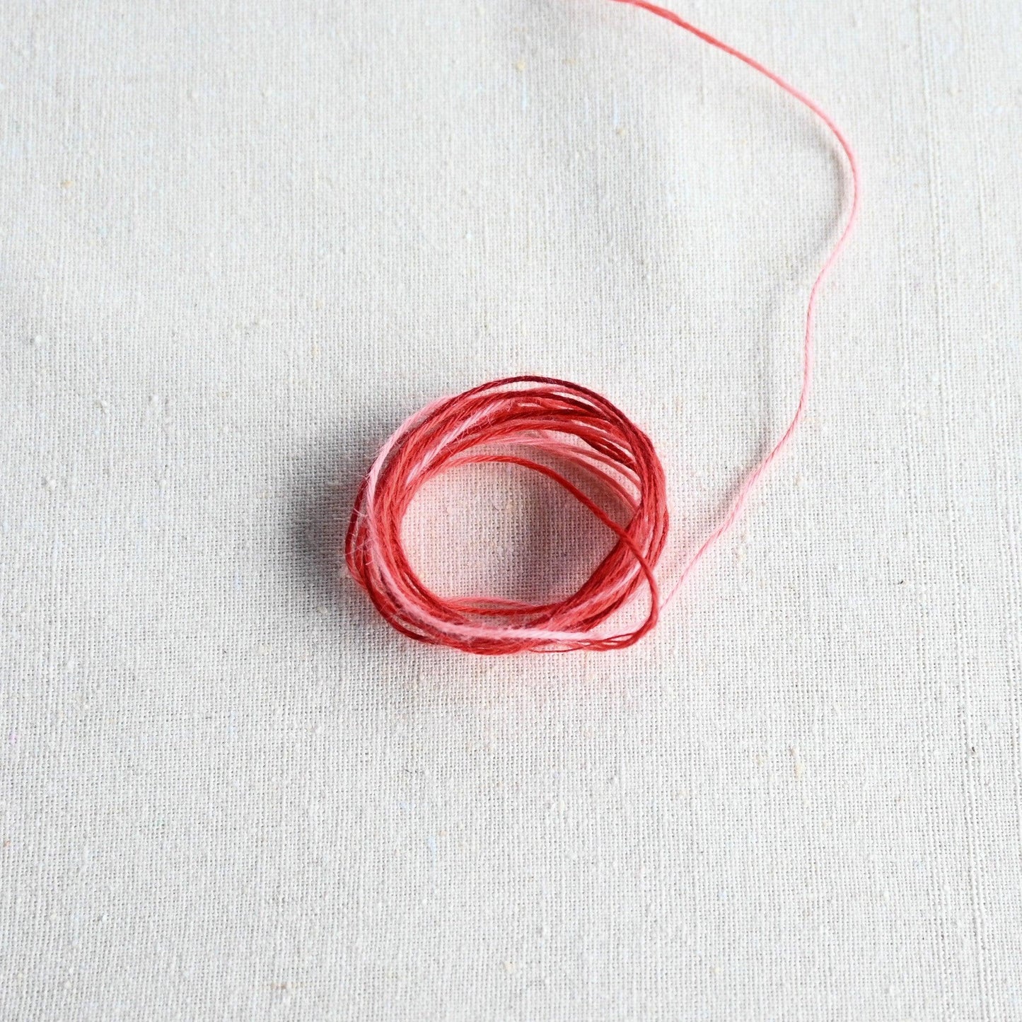 Authentic Japanese Hida sashiko threads in red gradation on calico cotton.
