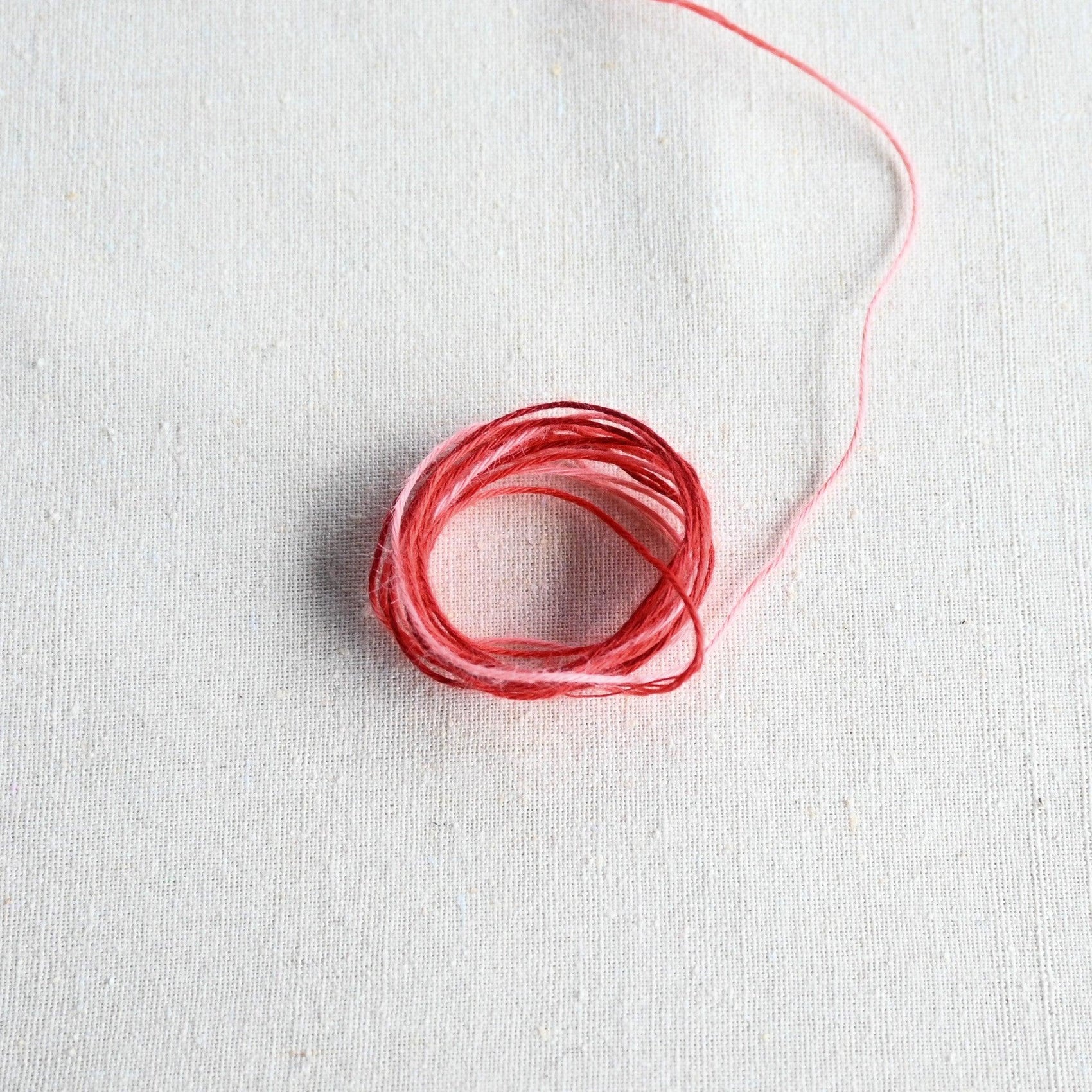 Authentic Japanese Hida sashiko threads in red gradation on calico cotton.