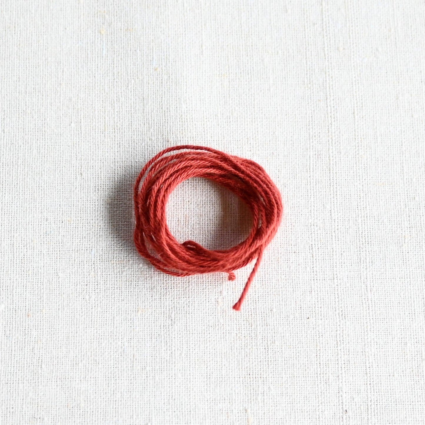 Authentic Japanese Hida sashiko threads in terracotta on calico cotton.