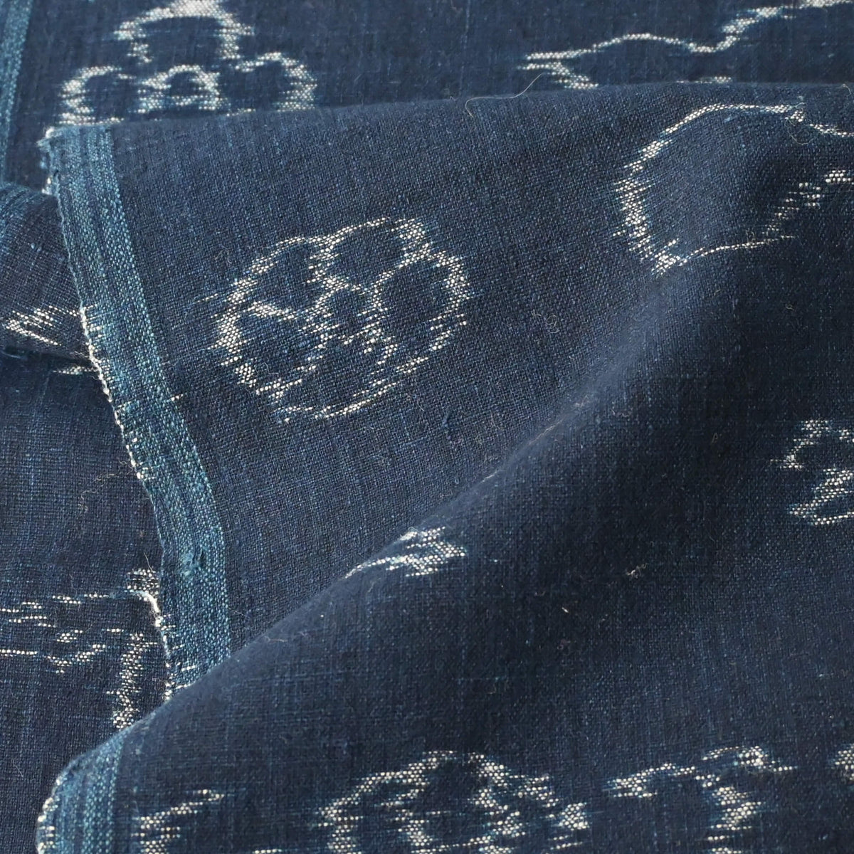 Detailed view of rare vintage indigo kasuri cotton with pictorial motifs,  including gourds, plum blossoms, and umbrellas.