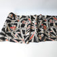Unrolled vintage Meisen silk kimono fabric in black with pink and red cubism floral pattern.