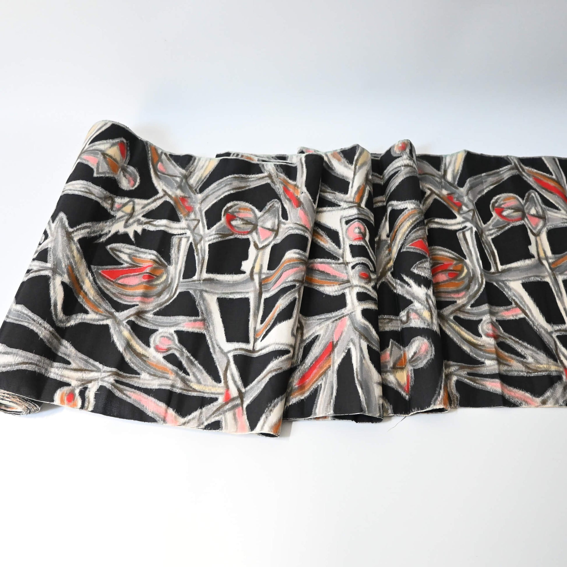 Unrolled vintage Meisen silk kimono fabric in black with pink and red cubism floral pattern.