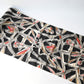 Wide view of vintage Meisen silk kimono fabric in black with pink and red cubism floral pattern.