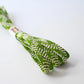 Close-up view of recycled silk obijime in a fresh matcha green with white accent.