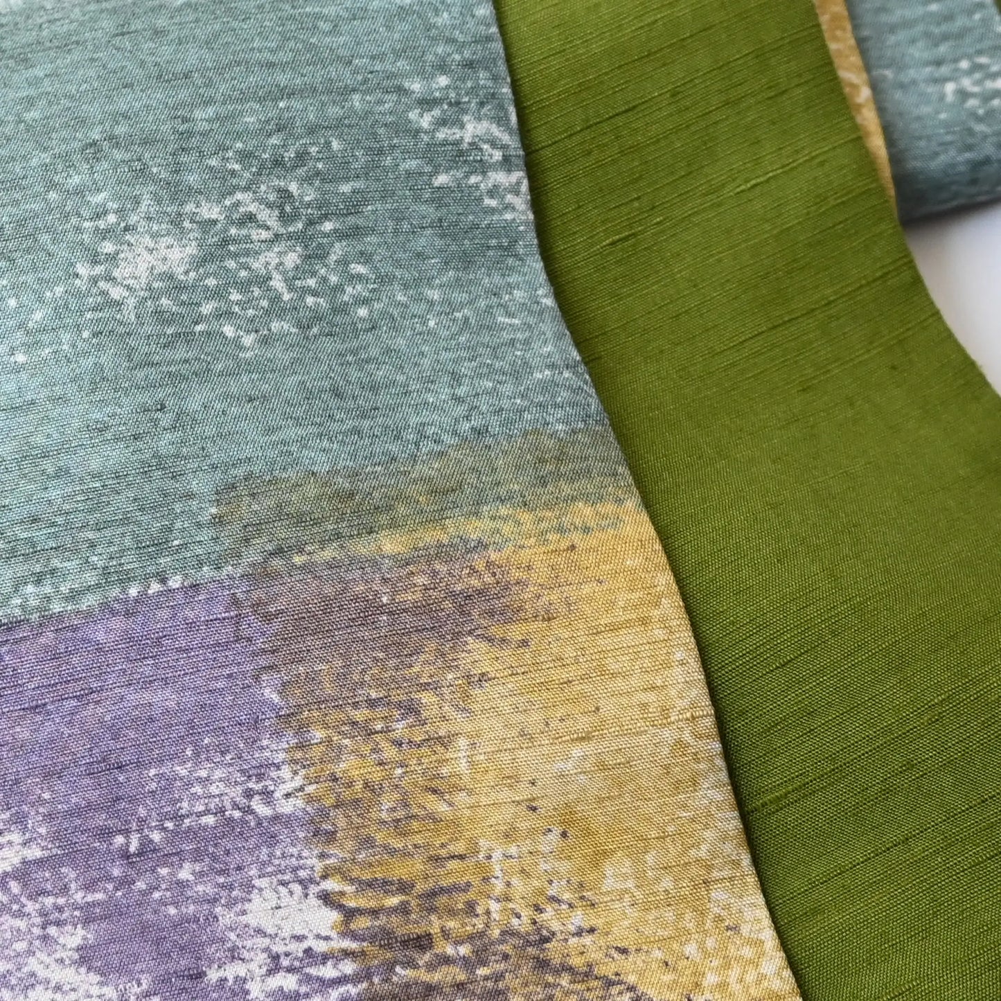 Close-up view of recycled women's tsumugi silk obi with dyed abstract painterly motif.