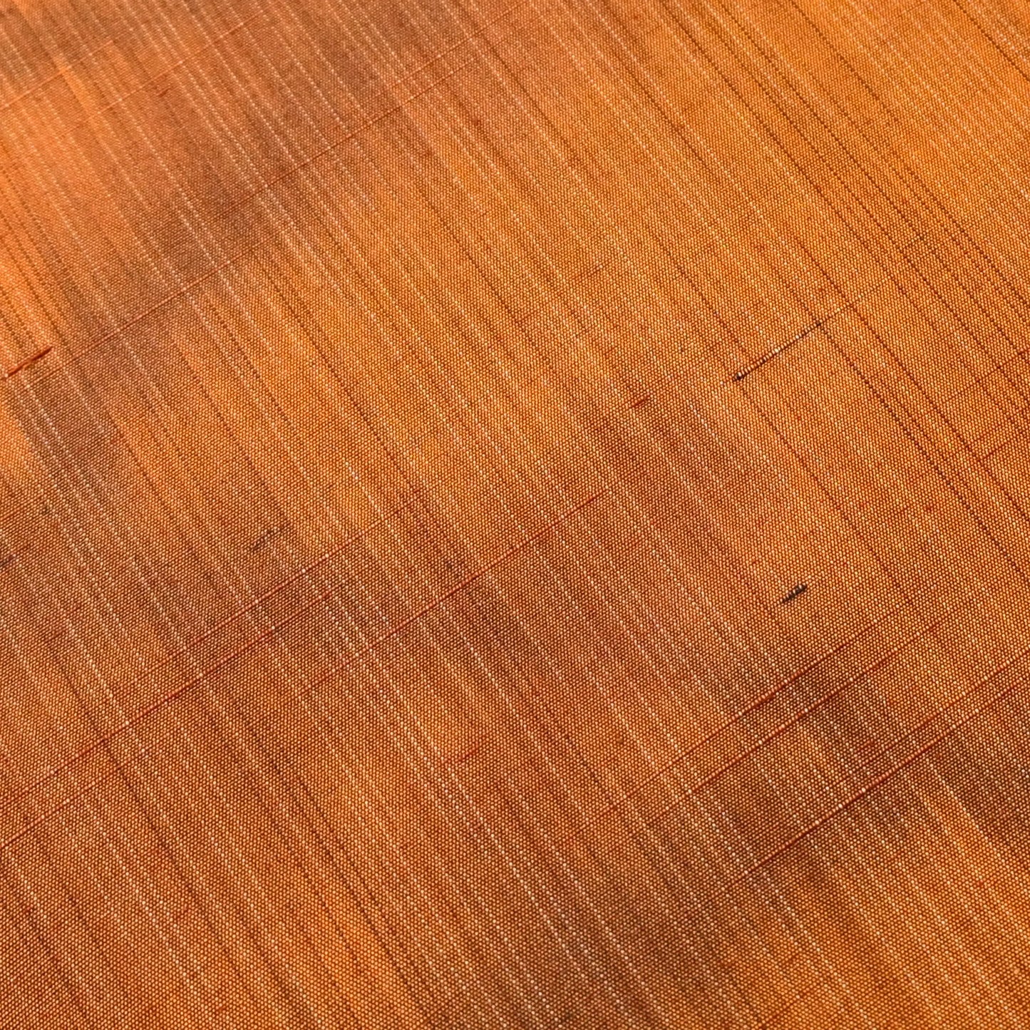 Detailed view of vintage amber brown tsumugi silk kimono fabric with abstract pattern, sold by the metre.