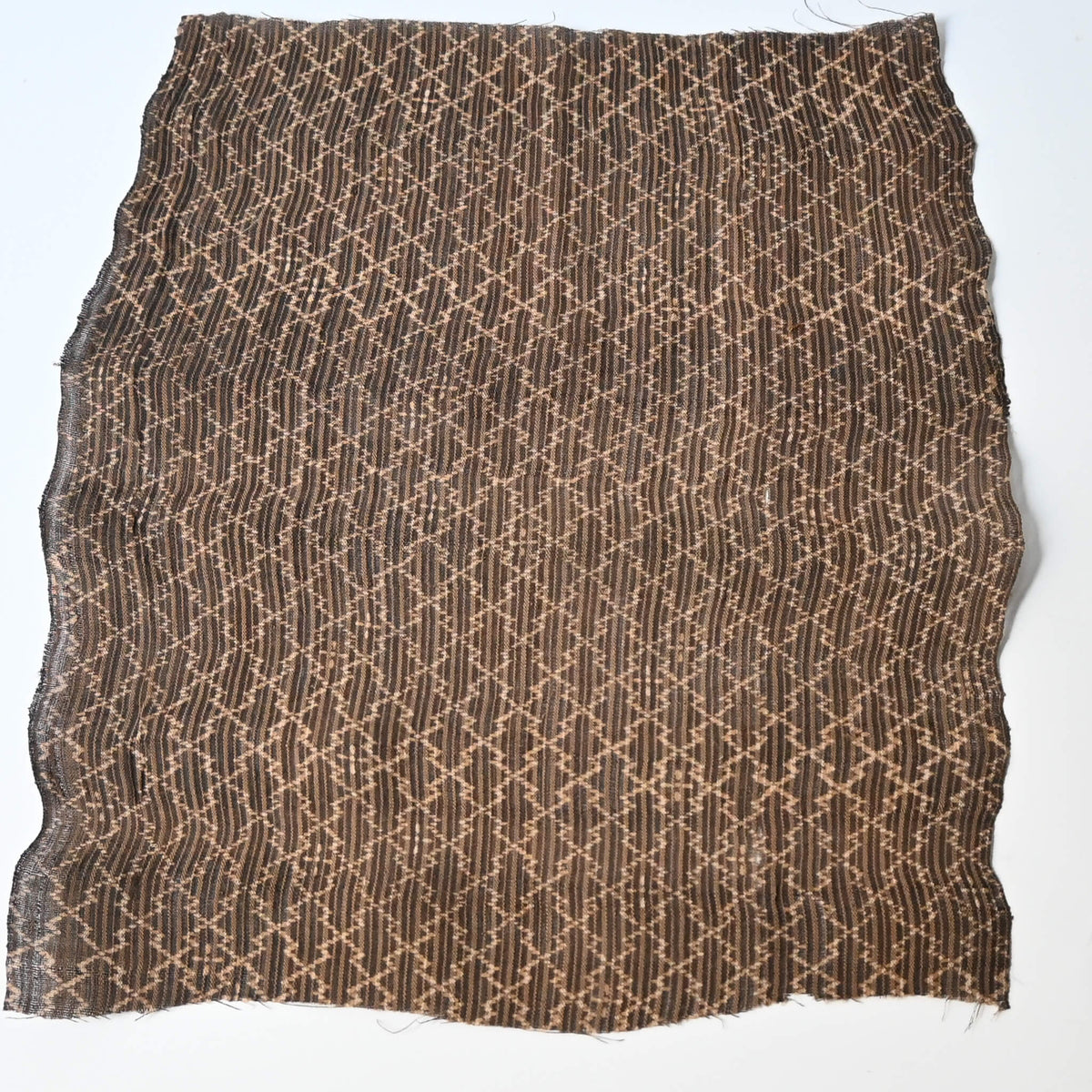 Full view of vintage collectable bashofu banana fibre textile fragment in rich brown with geometric pattern.