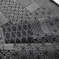 Close-up view of vintage black silk kimono fabric roll with patchwork-style geometric pattern, sold by the metre.