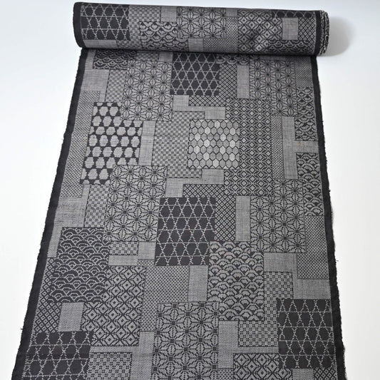 Full view of vintage black silk kimono fabric roll with patchwork-style geometric pattern, sold by the metre.