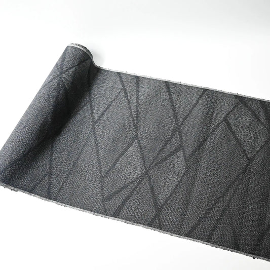 Full view of vintage black tsumugi silk kimono fabric roll with modern geometric pattern.