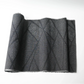 Vintage black tsumugi silk kimono fabric roll with modern geometric pattern.