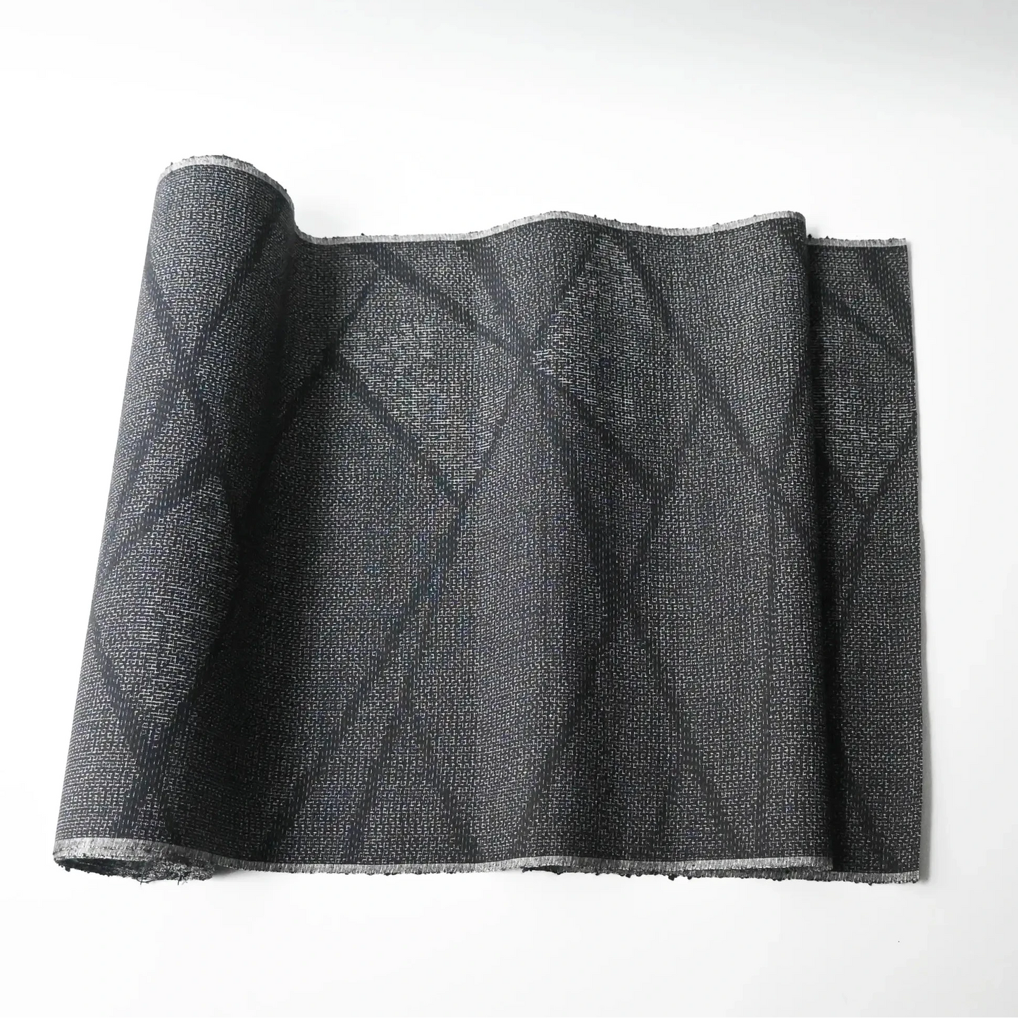 Vintage black tsumugi silk kimono fabric roll with modern geometric pattern.
