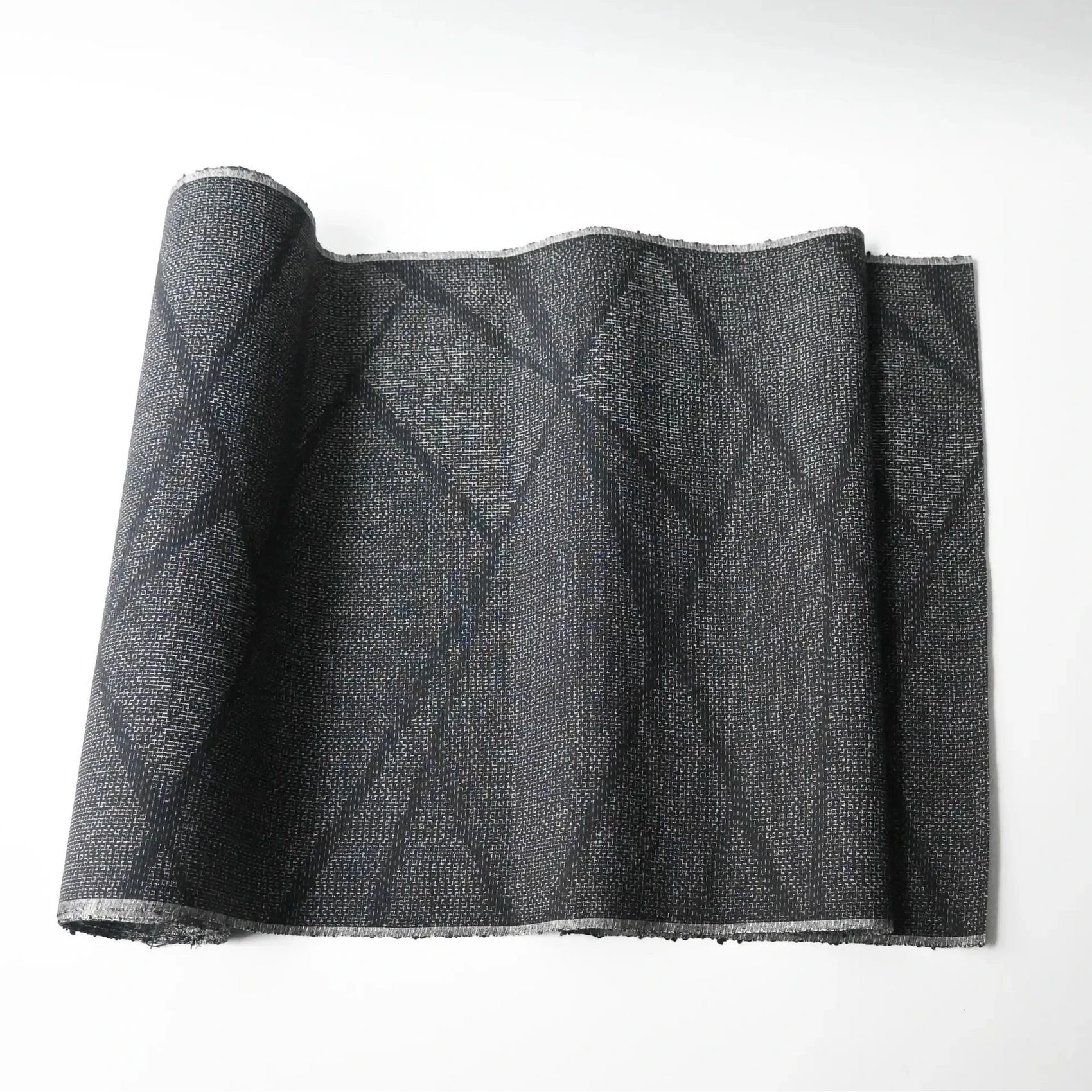 Vintage black tsumugi silk kimono fabric roll with modern geometric pattern.