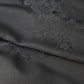 Close-up view of vintage Japanese black silk jacquard kimono fabric with floral motif, has a soft handle and drapes well.