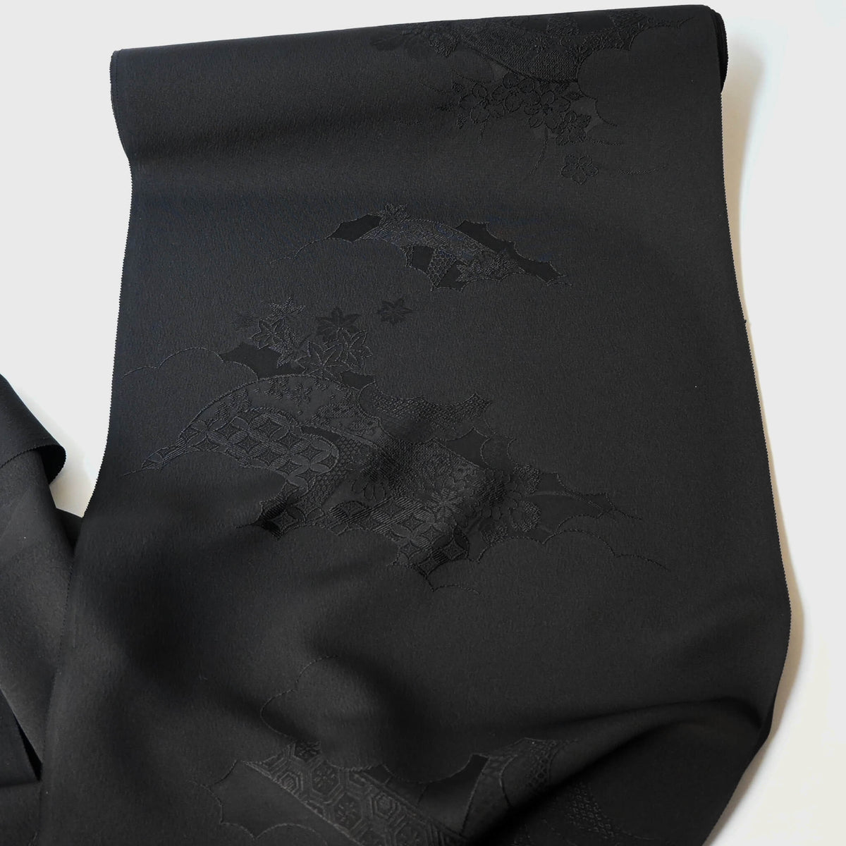 Full view of vintage Japanese black silk jacquard kimono fabric with floral motif, has a soft handle and drapes well.