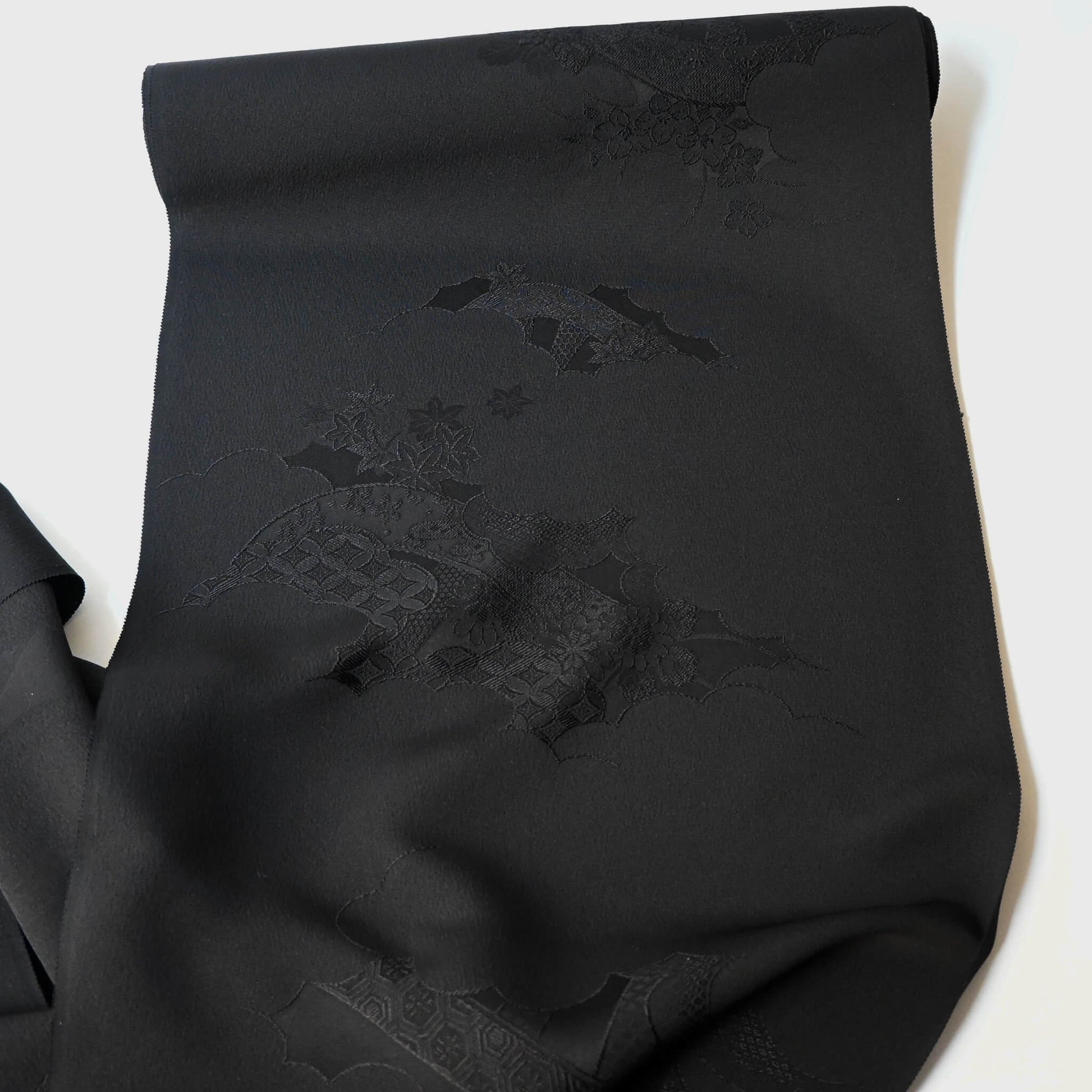 Full view of vintage Japanese black silk jacquard kimono fabric with floral motif, has a soft handle and drapes well.