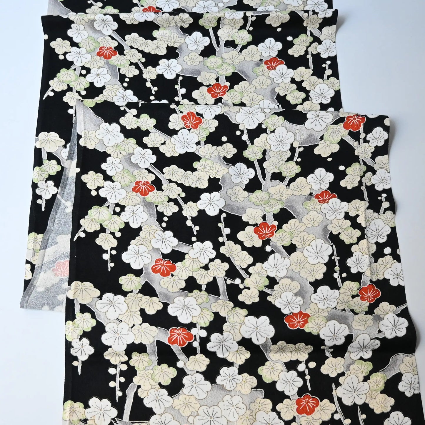 Vintage women's silk kimono fabric piece in black with plum blossom design.