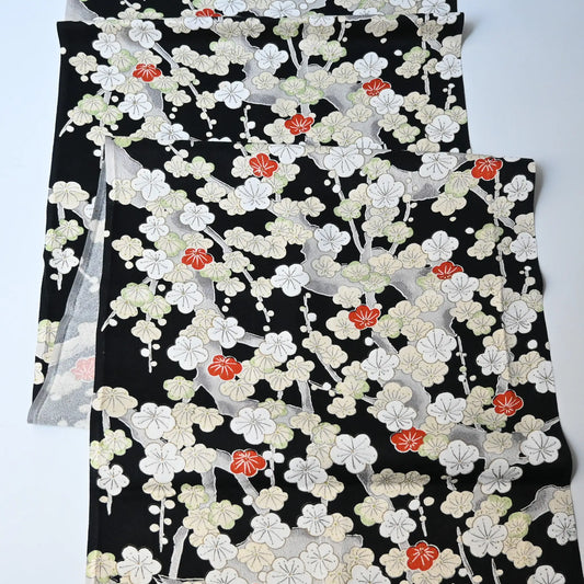 Vintage women's silk kimono fabric piece in black with plum blossom design.