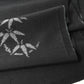 Close-up view of vintage Japanese tsumugi silk kimono fabric piece in black with small grey bamboo motif.