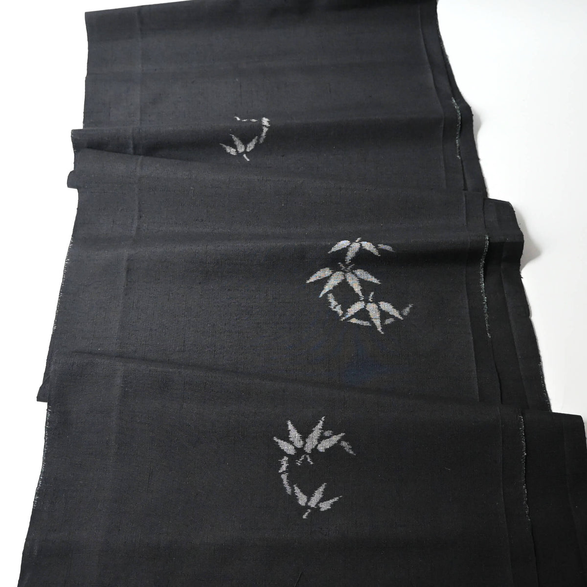 Full view of vintage Japanese tsumugi silk kimono fabric piece in black with small grey bamboo motif.