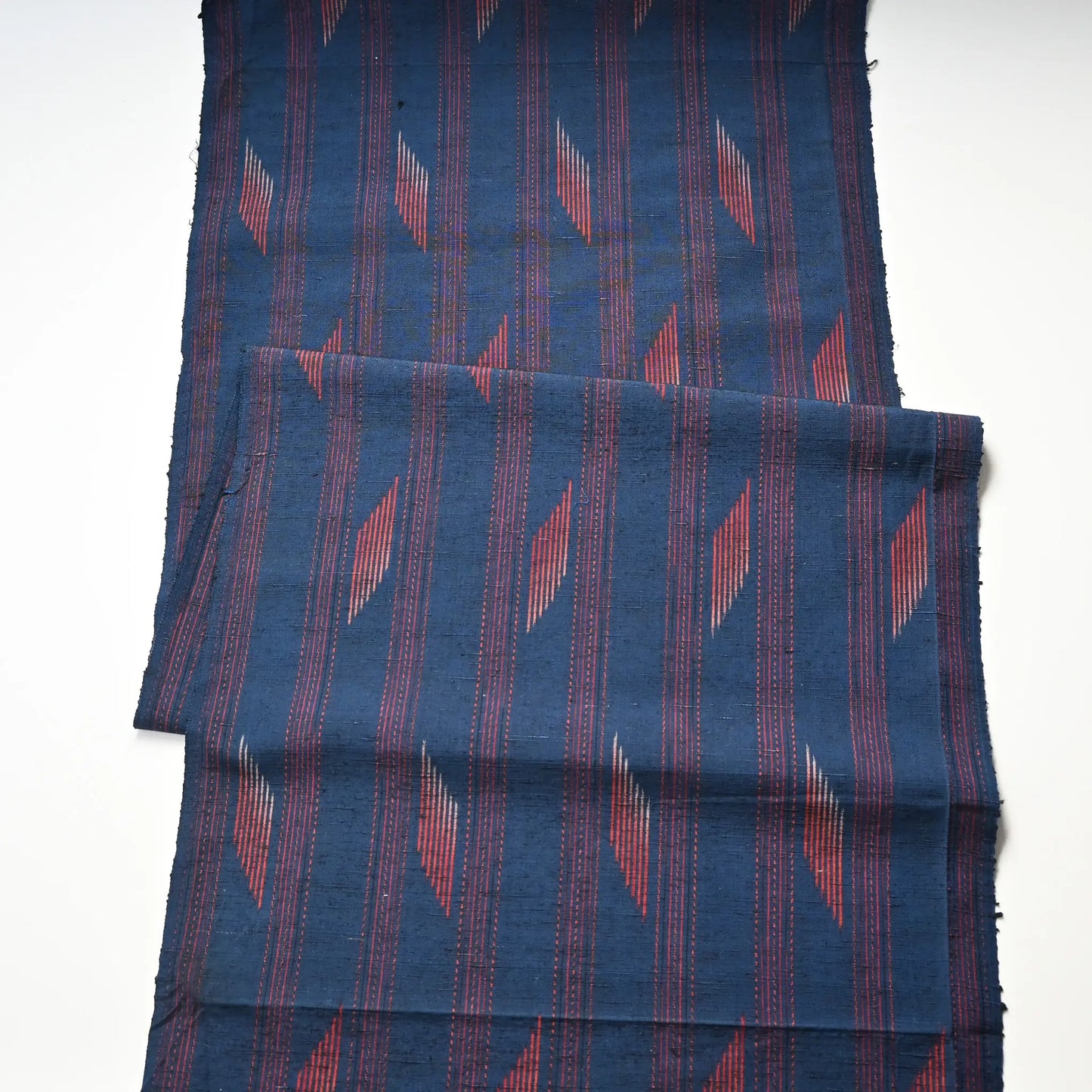 Full view of vintage Japanese blue tsumugi silk kimono fabric piece with red line pattern.