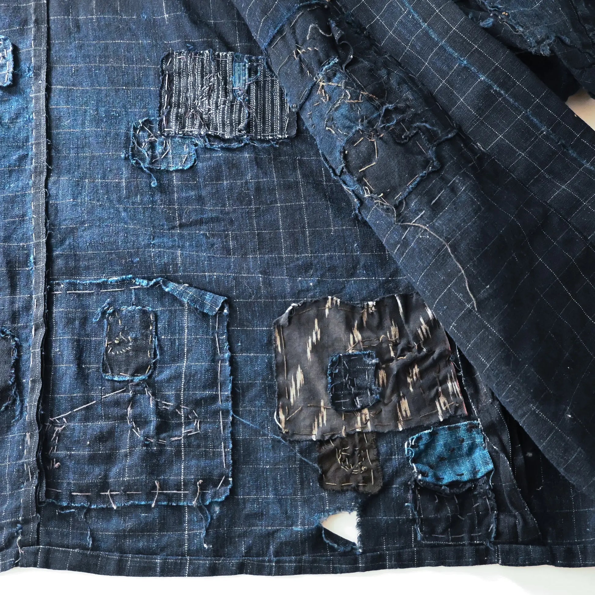 Detailed view of vintage Japanese Boro indigo cotton Noragi from the early to mid-20th century.