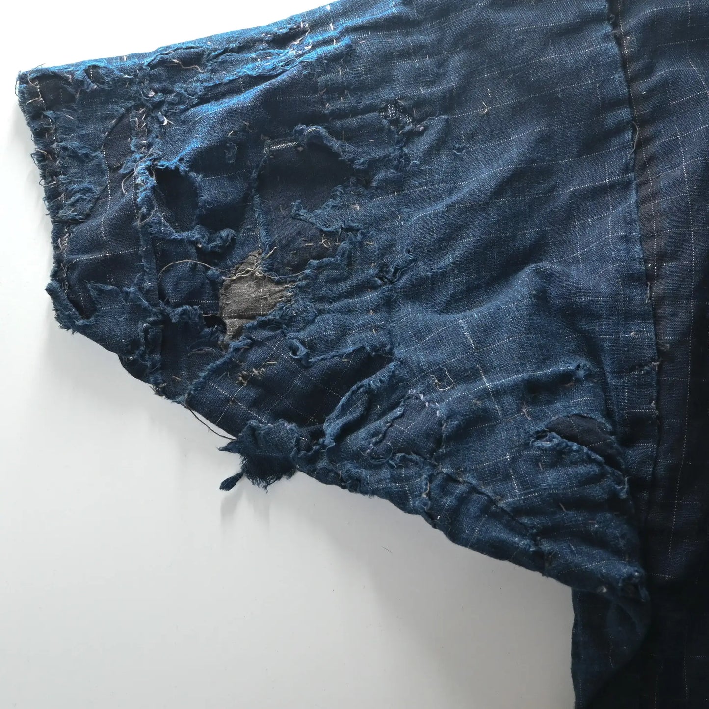 Detailed view of vintage Japanese Boro indigo cotton Noragi from the early to mid-20th century.