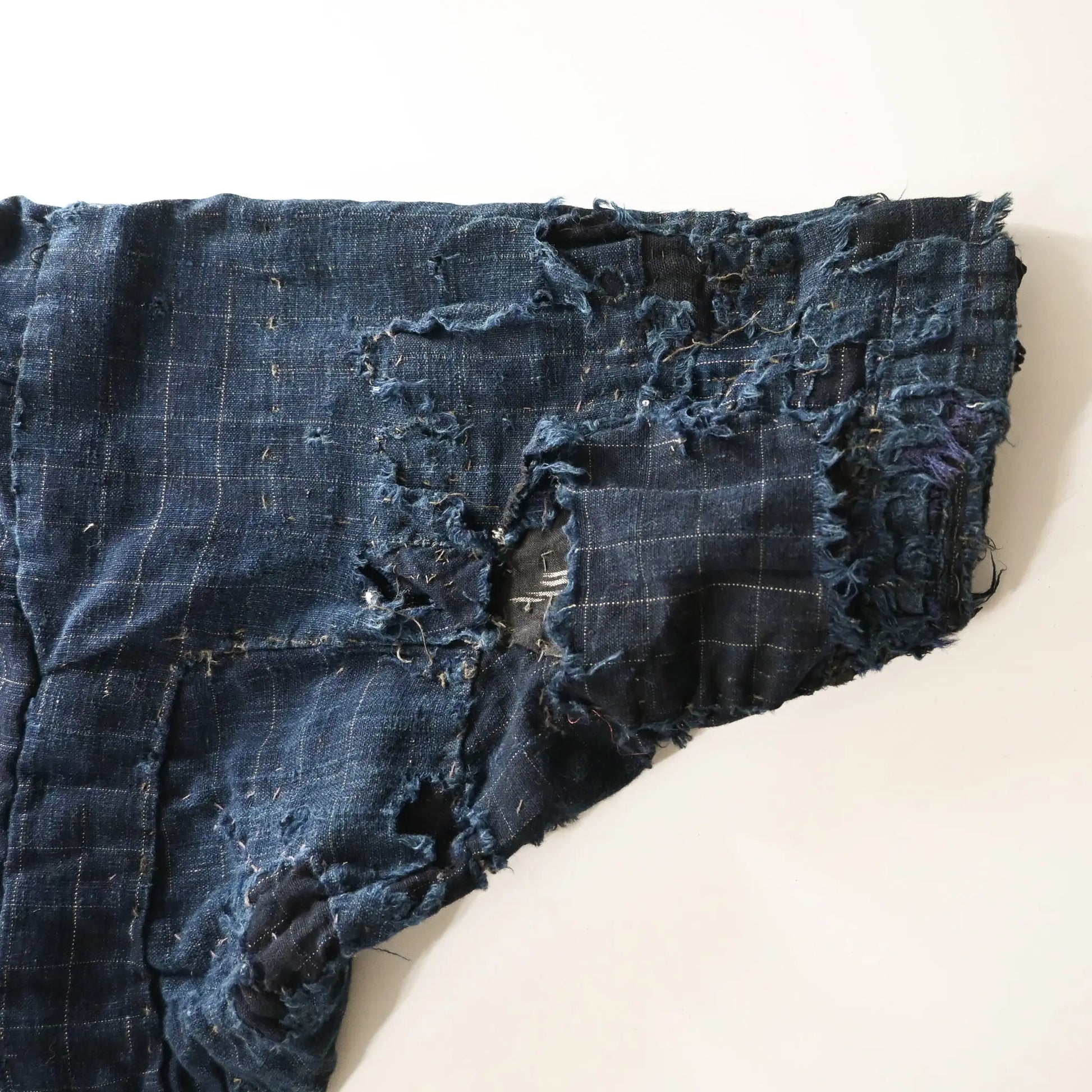Detailed view of vintage Japanese Boro indigo cotton Noragi from the early to mid-20th century.