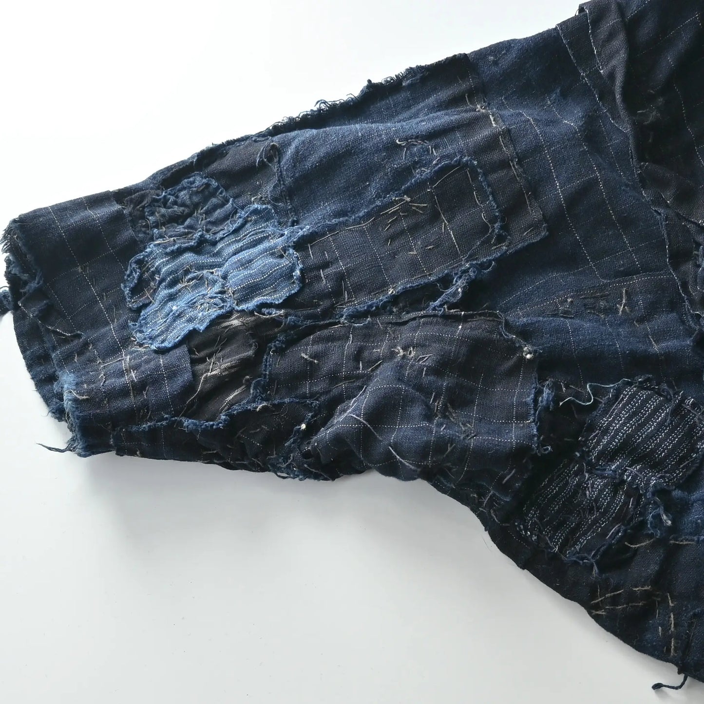 Detailed view of vintage Japanese Boro indigo cotton Noragi from the early to mid-20th century.