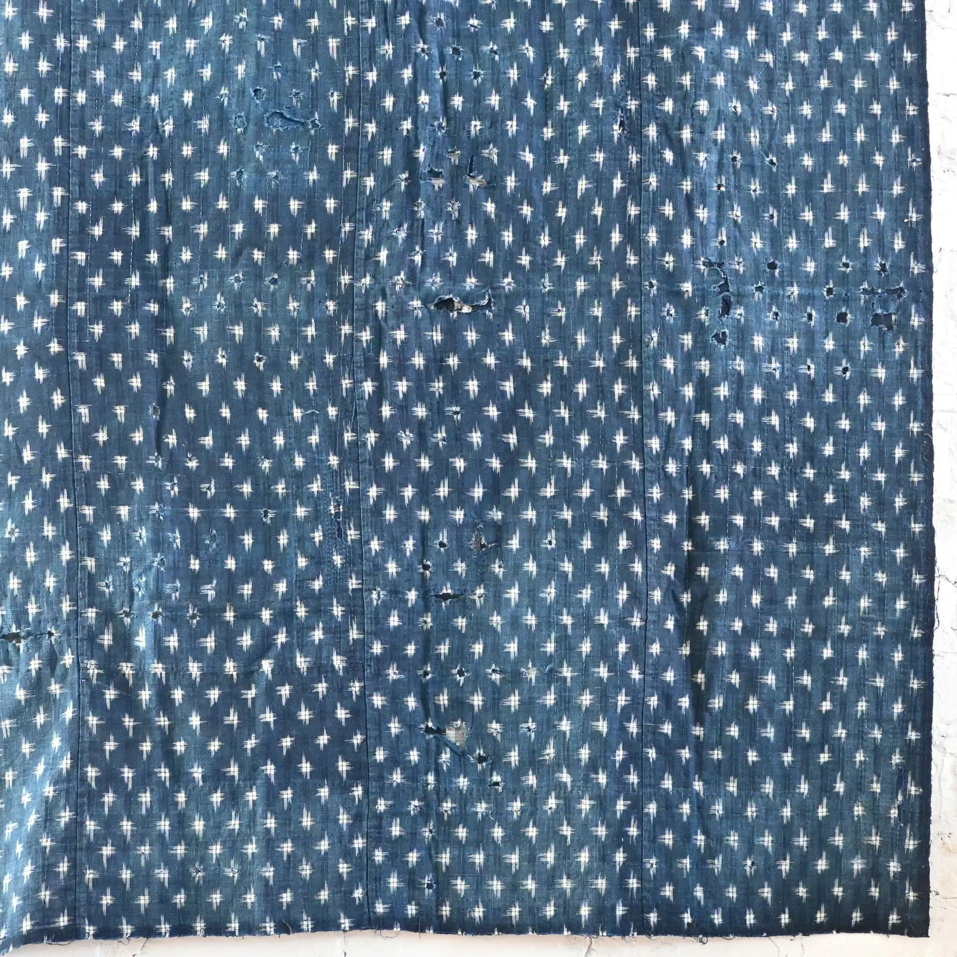 Detailed view of vintage Boro  indigo Kasuri cotton futon cover with patches and stitches.