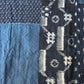 Detailed view of vintage Boro  indigo Kasuri cotton futon cover with patches and stitches.