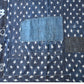 Detailed view of vintage Boro  indigo Kasuri cotton futon cover with patches and stitches.