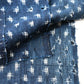 Detailed view of vintage Boro  indigo Kasuri cotton futon cover with patches and stitches.