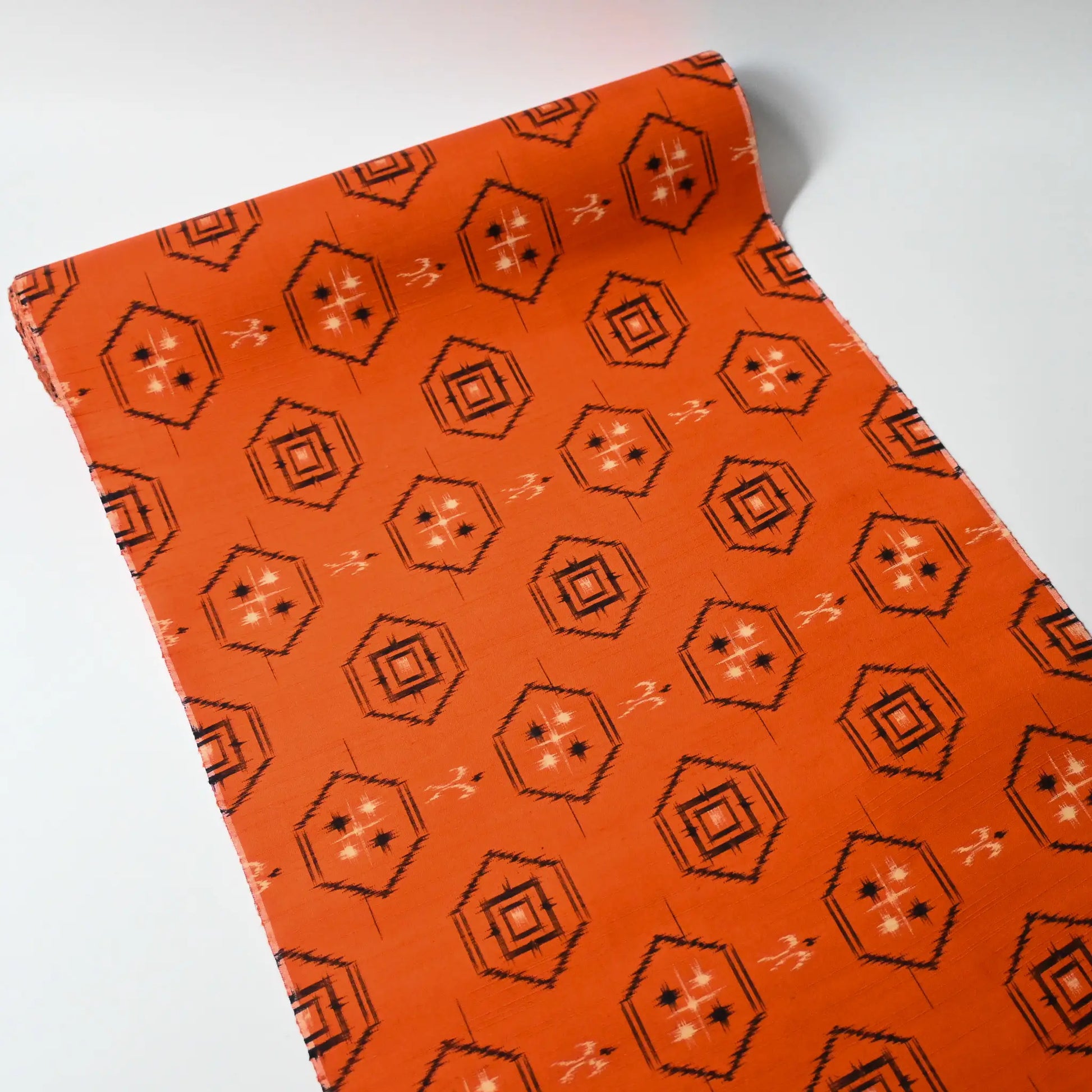 Full view of vintage bright tsumugi silk kimono fabric roll with black Kikko motif.