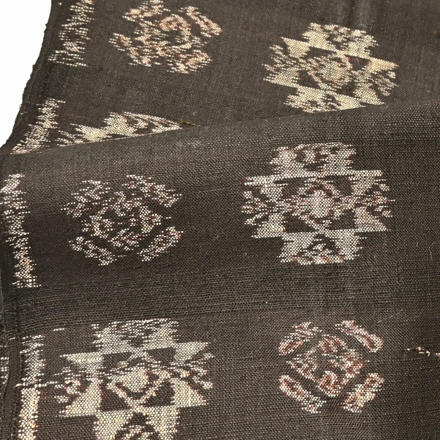 Detailed view of vintage Japanese silk kimono fabric in rich dark brown with kasuri woven pattern.