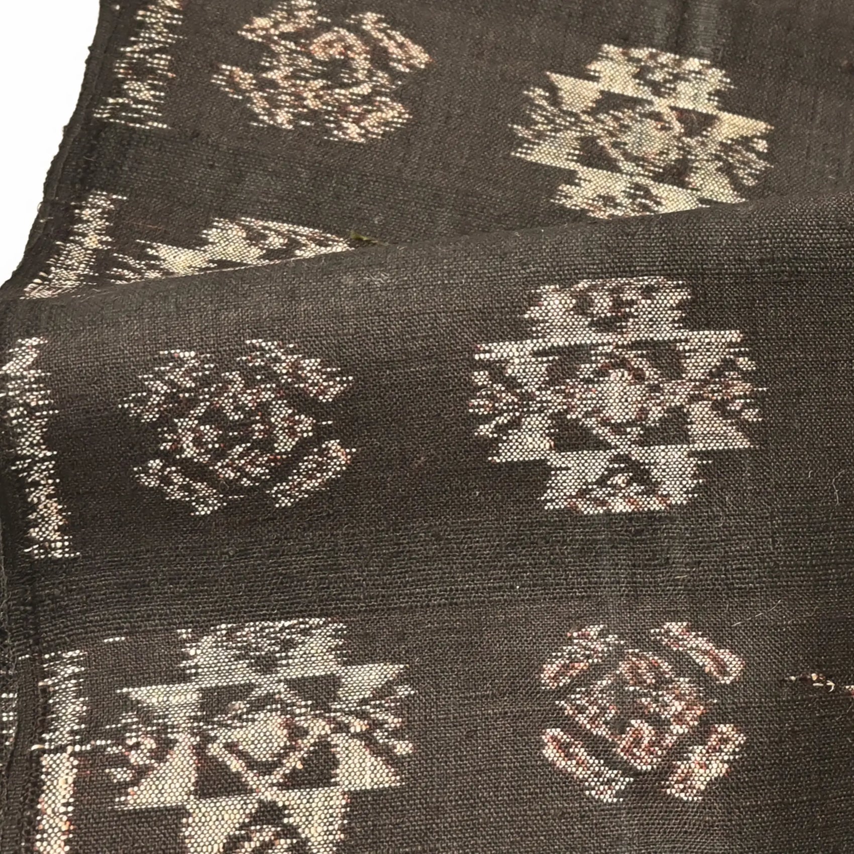 Detailed view of vintage Japanese silk kimono fabric in rich dark brown with kasuri woven pattern.