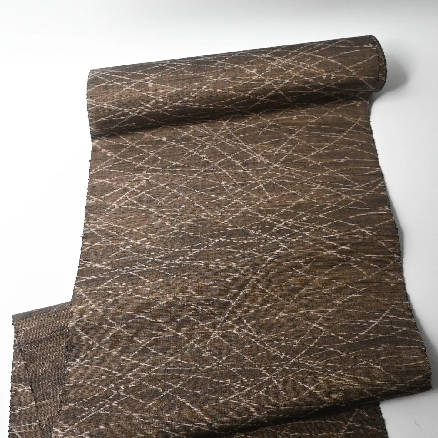 Full view of vintage Yuki tsumugi silk kimono fabric in brown and khaki-green tone with autumn grasses motif.