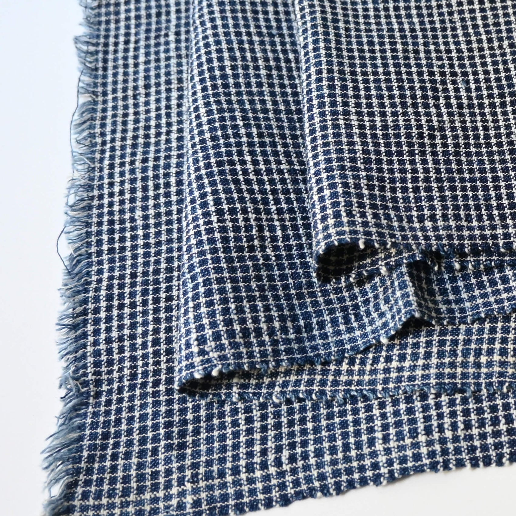 Close-up view of vintage Chinese hand loomed indigo check cotton piece.