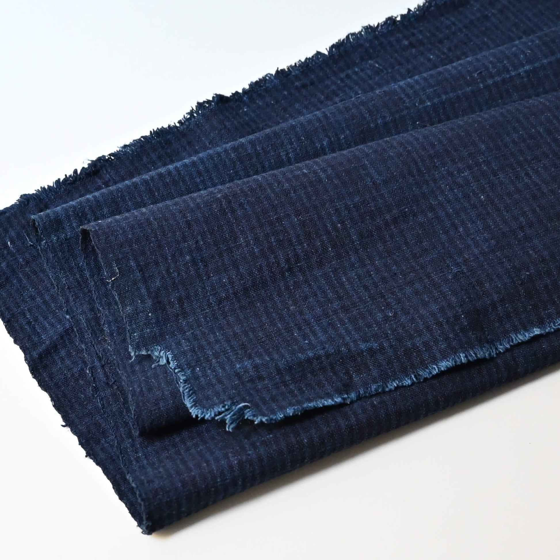 Close-up vintage Chinese indigo check cotton piece with natural texture.