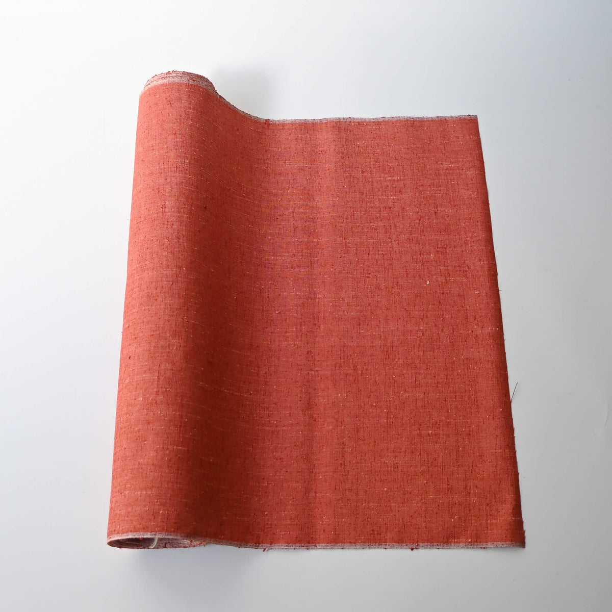 Vintage warm coral orange tsumugi silk kimono fabric with slubs, sold by the metre.