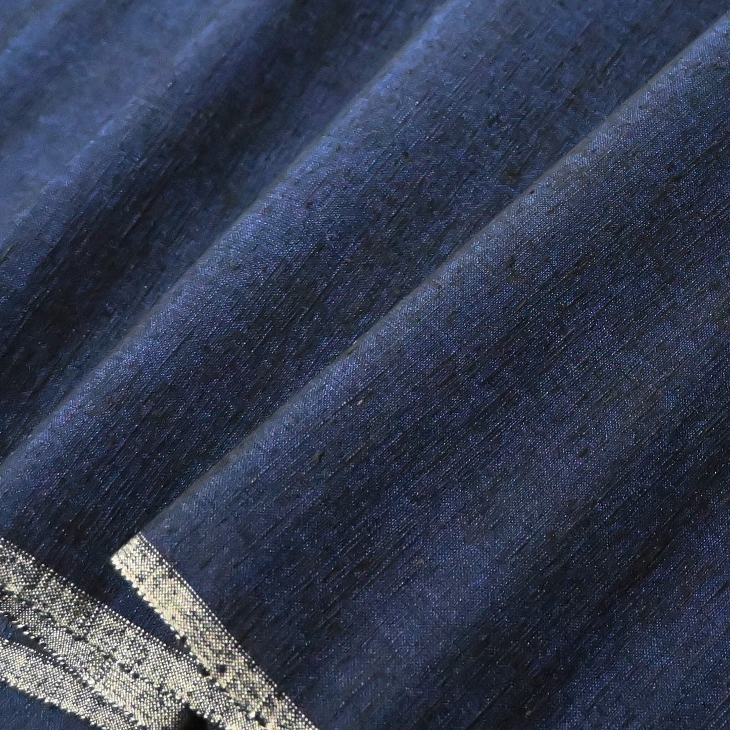 Close-up view of vintage deep rich blue tsumugi silk kimono fabric with natural slubs.