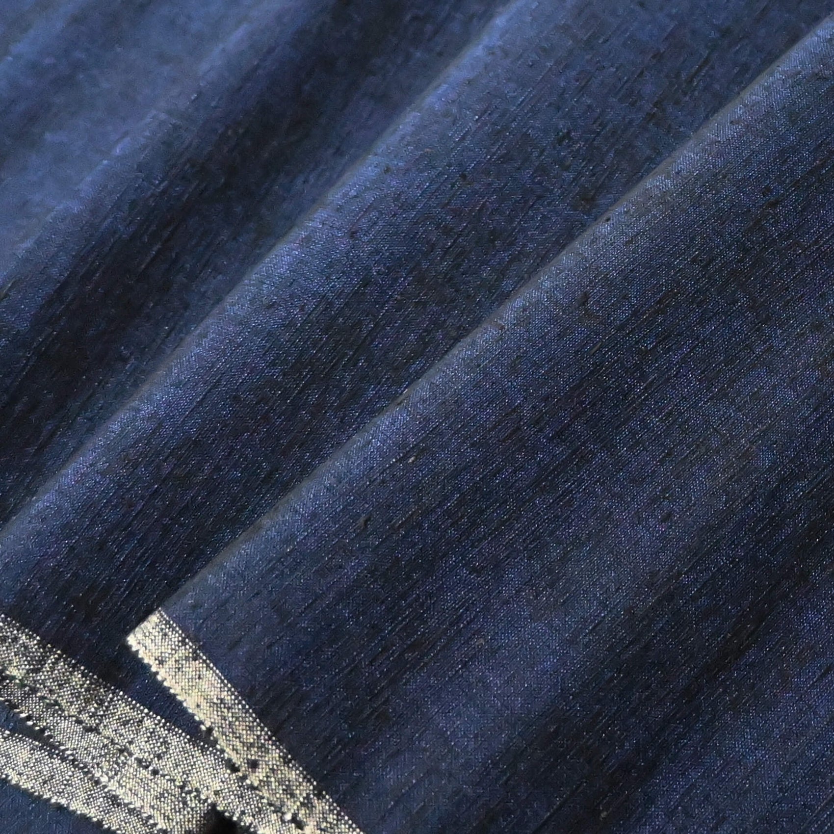 Close-up view of vintage deep rich blue tsumugi silk kimono fabric with natural slubs.
