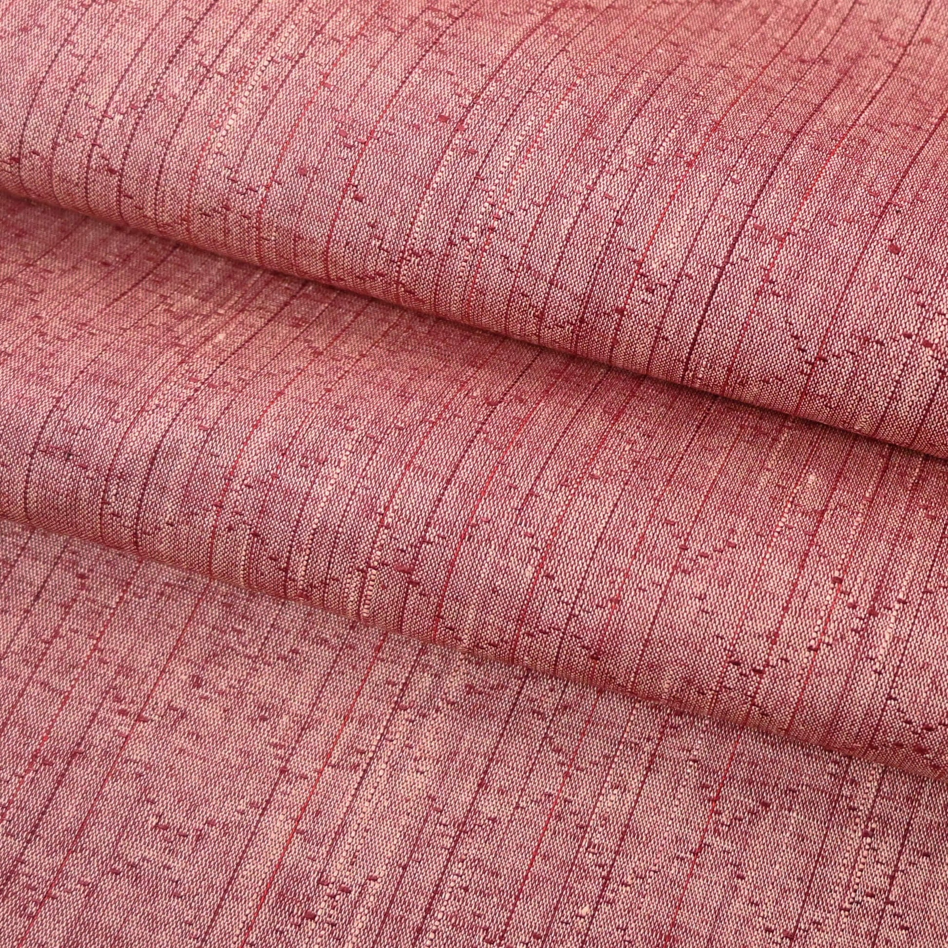 Close-up view of vintage dusty pink tsumugi silk kimono fabric sold by the metre.