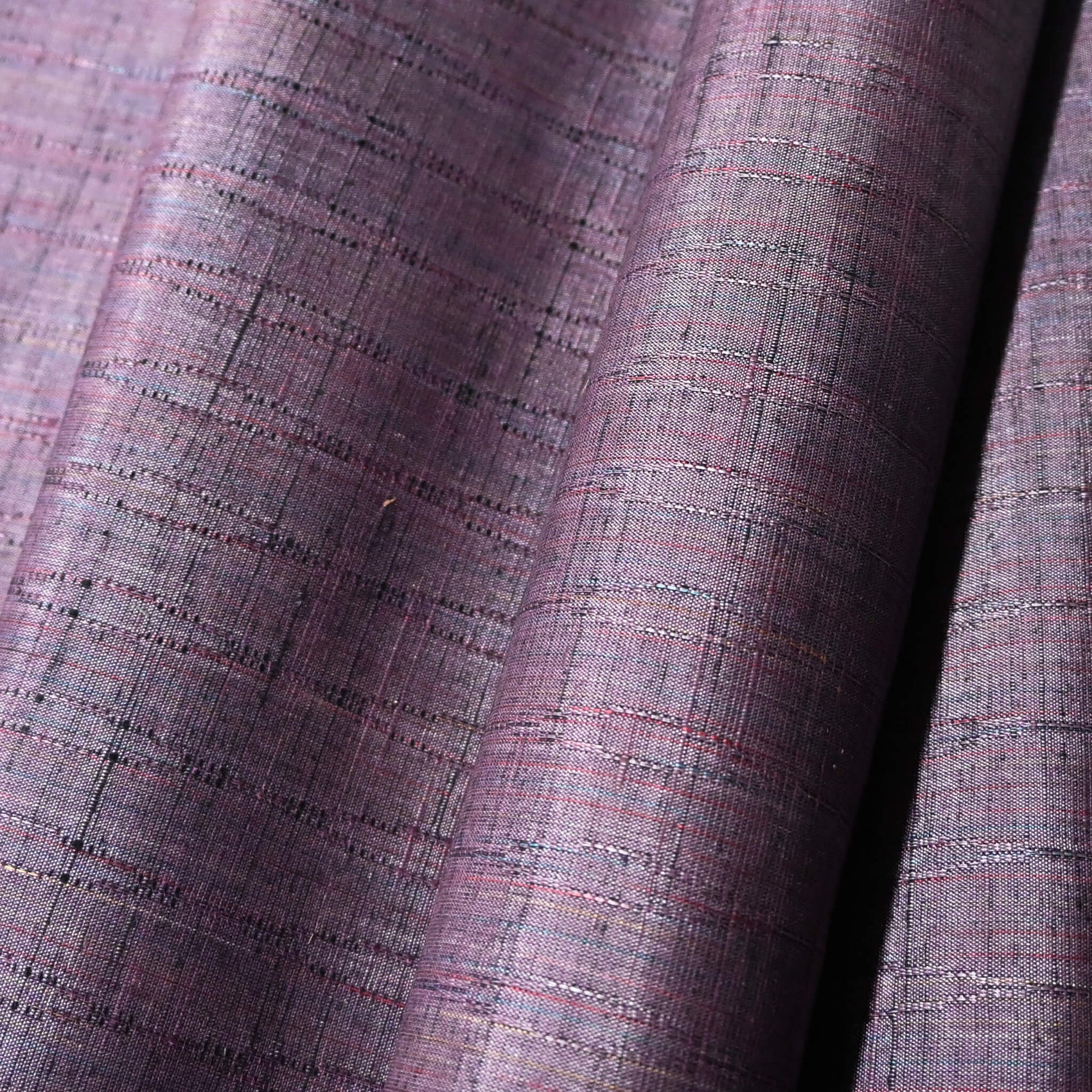 Close-up view of vintage dusty purple tsumugi silk kimono fabric sold by the metre.